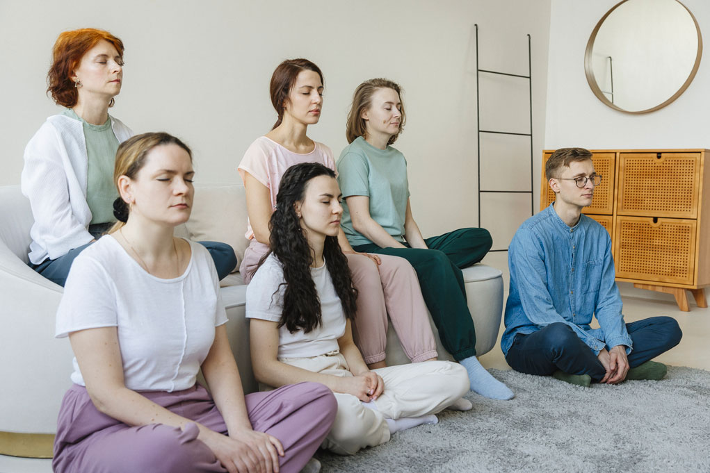 группа девушек практикует Трансцендентальную Медитацию с закрытыми глазами